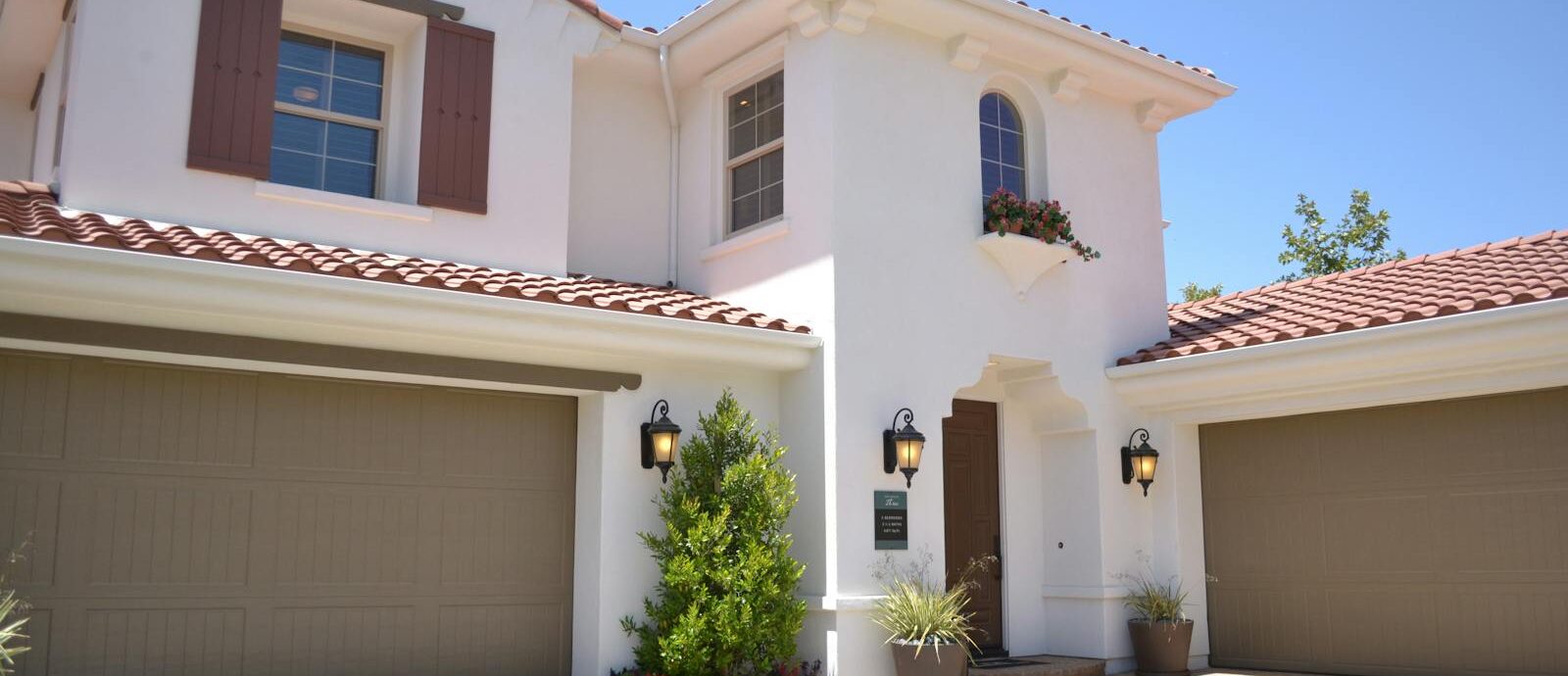 Bright suburban home with classic architecture and landscaped garden, ideal for real estate listings.