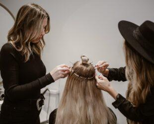 a woman getting her hair styled by another woman