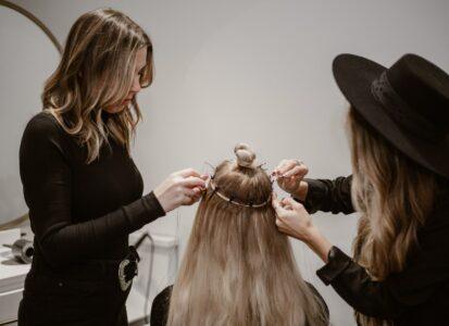 a woman getting her hair styled by another woman